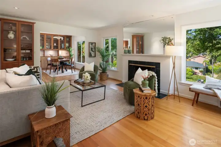 Wood burning fireplace and large picture windows create a light and inviting space that easily flows to the proper dining room. All with honey colored hard wood floors. Wood burning fireplace and large picture windows create a light and inviting space that easily flows to the proper dining room. All with honey colored hard wood floors.