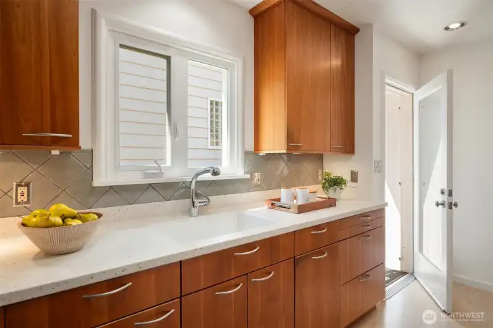 Warm and workable kitchen has access to the side yard and around to the back of the house. The Seller did not use a dishwasher, but there's plumbing and electrical ready for one if desired. Warm and workable kitchen has access to the side yard and around to the back of the house. The Seller did not use a dishwasher, but there's plumbing and electrical ready for one if desired.