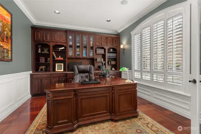 Off the entry, the den features a built-in credenza, and the L-shaped desk stays since it matches so well. The wainscoting adds richness.