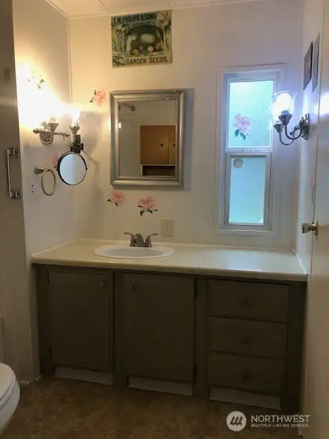 Light and bright bathroom with a nice window and good sized vanity.