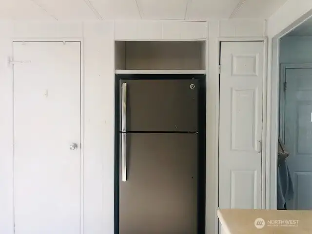 Flanking the refrigerator is a pantry and coat or broom closet