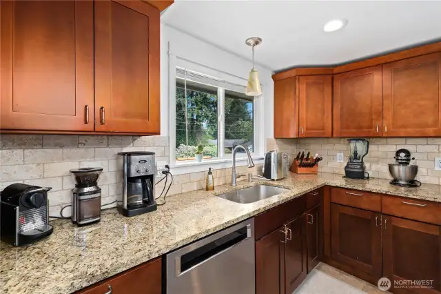 Kitchen with the deep wood cupboards. Full bucket sink with window that looks out front yard.
