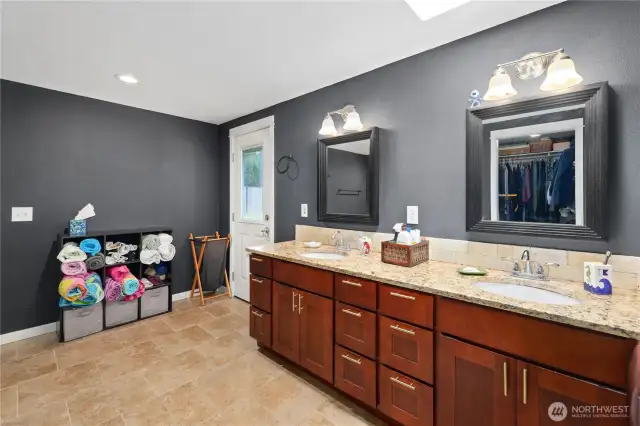 Primary bathroom with granite double sink with door to backyard convenience