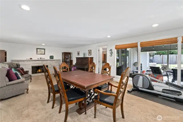 Huge living area with fireplace and windows and brightness flowing thru windows into the covered patio