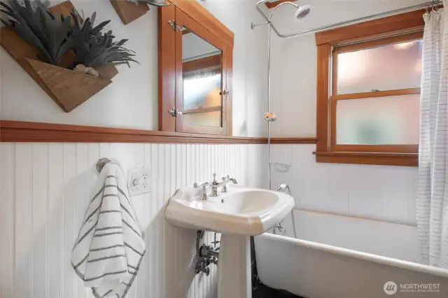 Main level bathroom keeps the style classic    with clawfoot tub & pedestal sink, but adds a touch of modern with cozy heated floors.