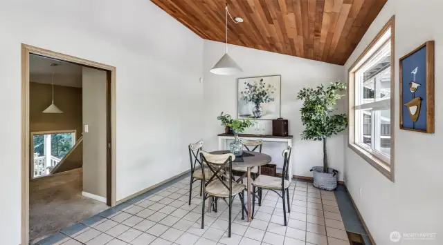 This striking dining room showcases a vaulted rich wood ceiling that beautifully contrasts with the crisp white walls.