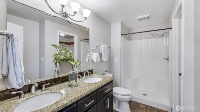 The luxurious en suite bathroom boasts a modern walk-in shower and a sleek double vanity, perfect for a refined daily routine.