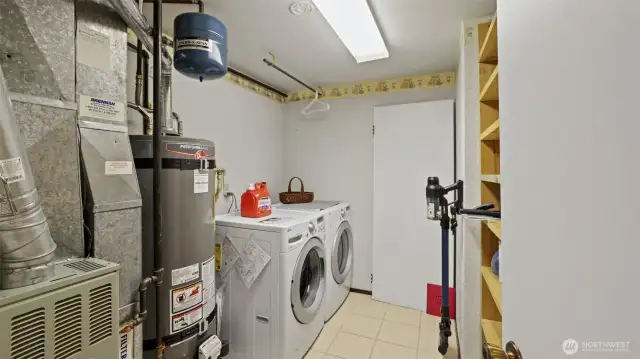 This spacious utility room on the lower level offers a convenient option for laundry and added storage space.
