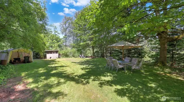 Spacious yard offers a variety of uses with different areas throughout - enjoy this open area for pets, gatherings, and outdoor fun. Includes storage space for tools and equipment, a handy shed, fire pit, plus room for tables and chairs to unwind and entertain.