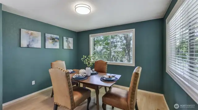 Beautifully painted dining room with two generously sized windows and seamless access to kitchen and living room for effortless entertaining.