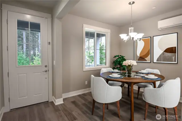 Open concept dinning room with window that has view of green belt (Virtually Staged)