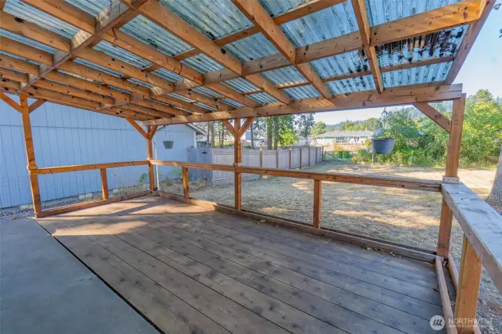 Covered deck overlooking the fenced back yard.