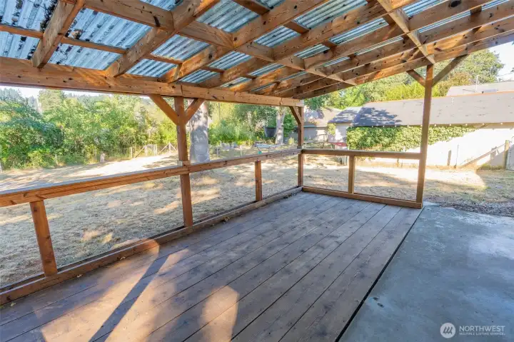 Spacious covered patio allowing for natural lighting and an inviting outdoor living space with a rustic charm.
