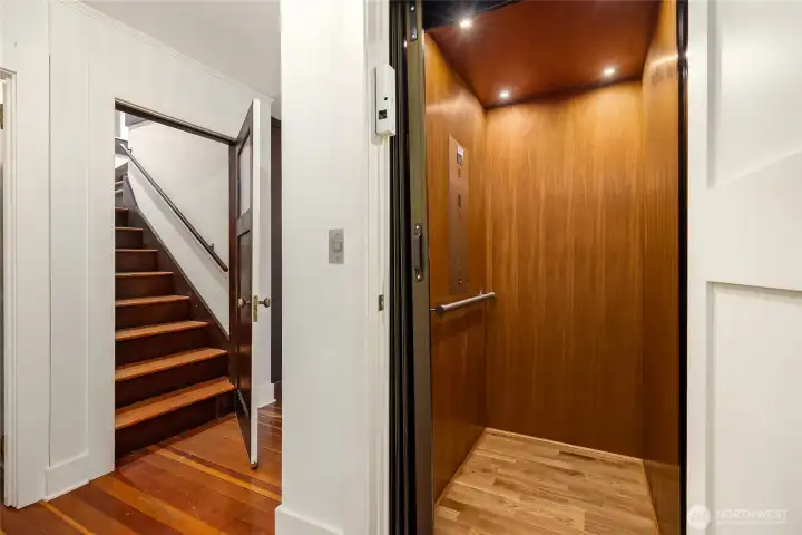 The elevator 2nd floor arrival located in the hallway. Also shown, the stairs to the top floor of the home.
