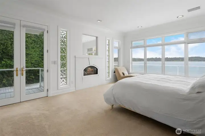 Huge primary bedroom with fireplace and doors to the outside deck.