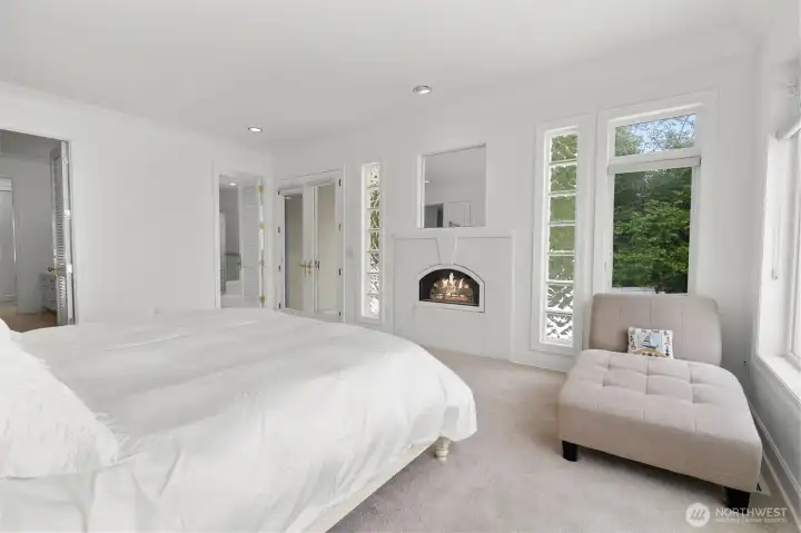 Another view of the primary bedroom showing doors to the extensive en suite bathroom and two matching walking closet.