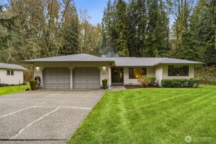 Welcoming front exterior with expansive yard, offering privacy, usable space, and a beautiful first impression.