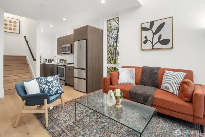Open-concept living and kitchen area with warm cabinetry, stainless steel appliances, and a stylish, modern layout that flows effortlessly for both everyday living and entertaining.