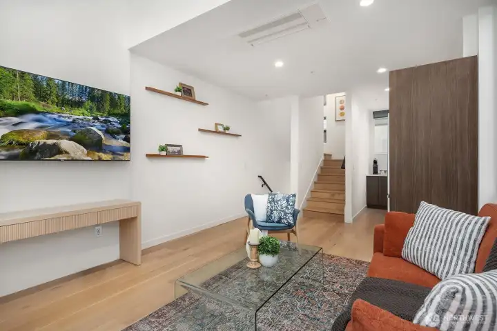 Sleek and modern living space with engineered hardwood floors, custom built-in shelving, and a clean, minimalist aesthetic that makes the most of every square foot in this thoughtfully designed home.