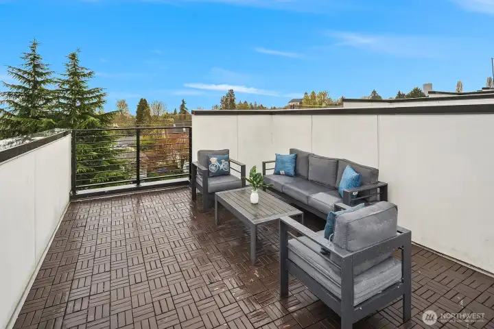 Private rooftop deck with stylish outdoor seating, open sky views, and a sun-soaked setting perfect for morning coffee, evening gatherings, or simply soaking in the best of Seattle living.