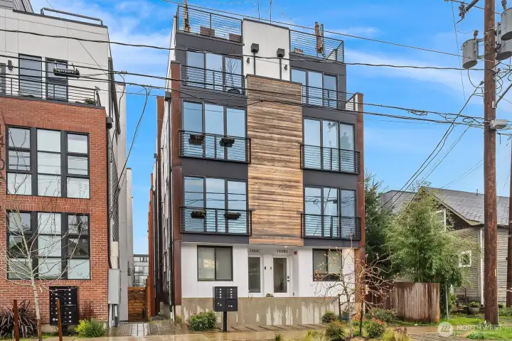 Handsome end-unit facade with bold modern lines, expansive windows, and a coveted corner position offering exceptional natural light and urban privacy in the heart of Seattle.