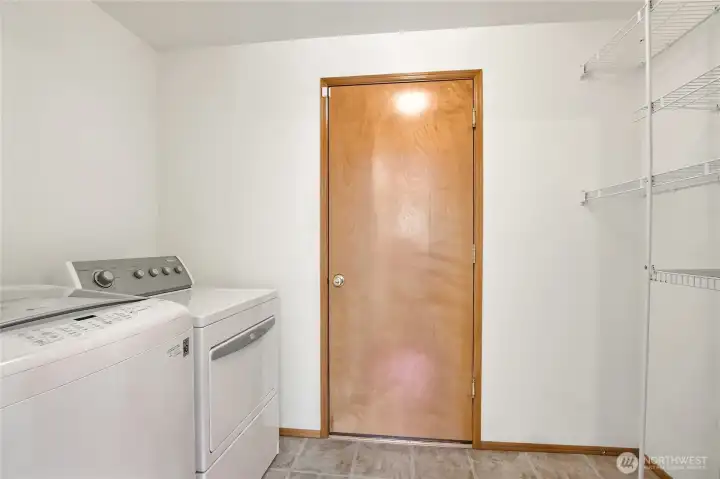 The laundry room is in the mudroom from the garage and has storage shelves