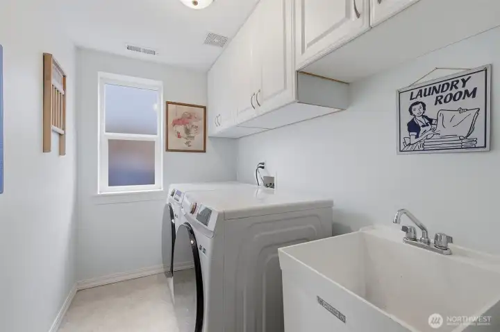 Laundry features newer washer and dryer that stay, storage cabinets and laundry tub. Laundry features newer washer and dryer that stay, storage cabinets and laundry tub.