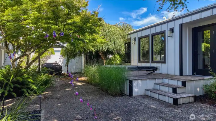 The interior garden area of the property includes immaculate landscaping and a hot tub off the main house.
