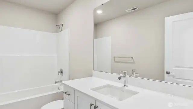 Hall bath with quartz countertops, white cabinets an option that can be added early in the construction process