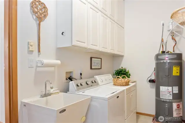 Large laundry room with tons of storage, wash basin, 2017 water heater and access to 2-car garage