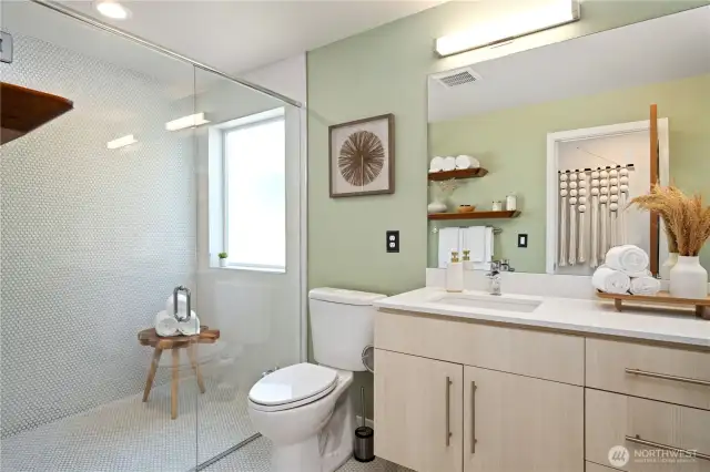 Hall bath with large walk-in shower adjoins primary bedroom.