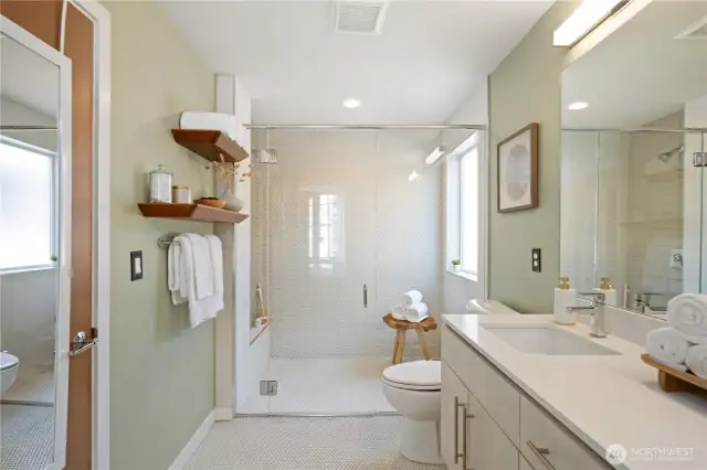 Hall bath with large walk-in shower adjoins primary bedroom.