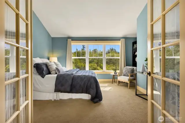 Upstairs, French doors open to the primary suite