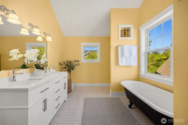 Extra-long clawfoot tub below the large picture window. Note the stained glass above the tub.