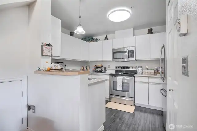 convenient kitchen setting with lots of cabinets and eating bar