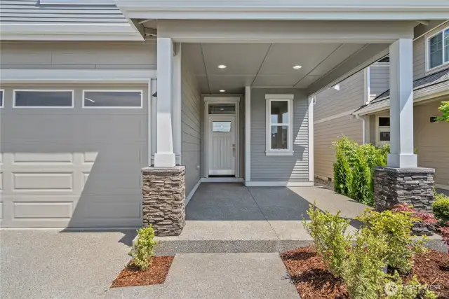 Relax and enjoy the oversized covered front porch with decorative stone panels.