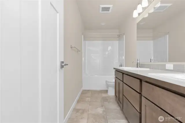 Main Full bath with double vanity undermount sinks with contemporary fixtures, quartz countertop and tub/shower.