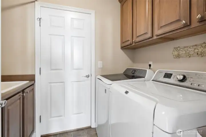 The main floor laundry room with utility sink hosts lots of storage and is conveniently located just off of the garage entry into the home.