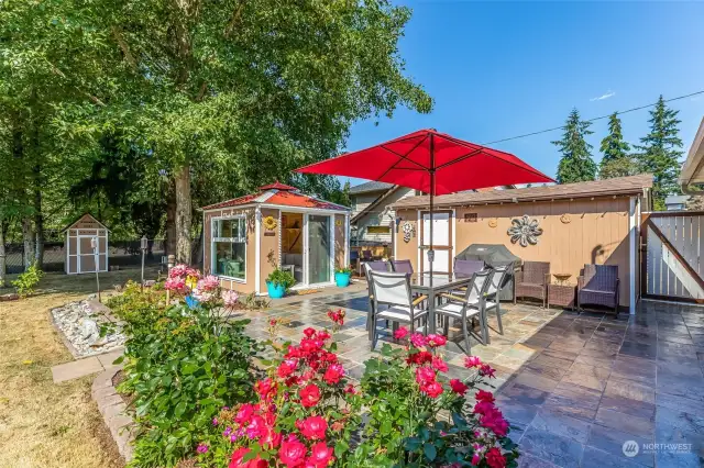 Step out into this backyard oasis, the  ultimate entertaining space. An ENORMOUS  slate tile patio (makes a great dance floor),  detached guest room/ hobby room/ studio,  plus 2 more outbuildings for all your storage  needs.