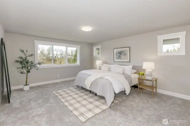 Spacious Primary Ensuite with sweeping views of sunsets & evergreen trees. Photo is of the staged model, the same 2,958 sf floor plan as the listed home.  Colors vary.