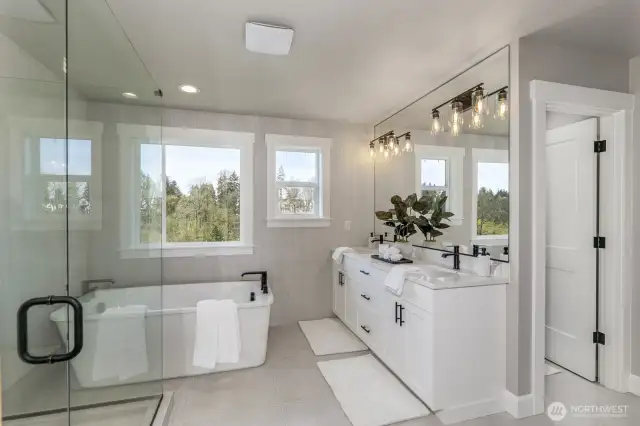 Luxurious Primary Bathroom with separate soaking tub. Photo is of the staged model, the same 2,958 sf floor plan as the listed home.  Colors vary.
