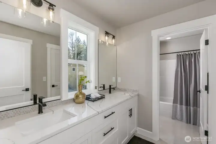 Upper hallway bath with large vanity & private shower room. Photo is of the staged model. Colors vary.
