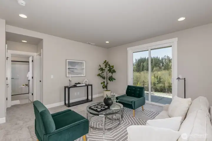 Sunny lower daylight basement offers a 2nd living room and door to covered patio. Photo is of the staged model. Colors vary.
