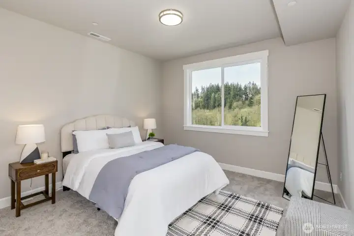 Large daylight basement guest bedroom. Photo is of the staged model. Colors vary.