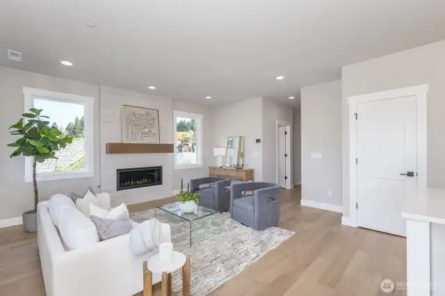 Living room with huge gas fireplace. Photo is of the staged model, the same 2,958 sf floor plan as the listed home.  Colors vary.