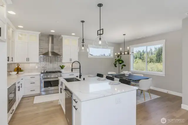 Sunny kitchen and dining room with a beautiful view. Photo is of the staged model, the same 2,958 sf floor plan as the listed home.  Colors vary.