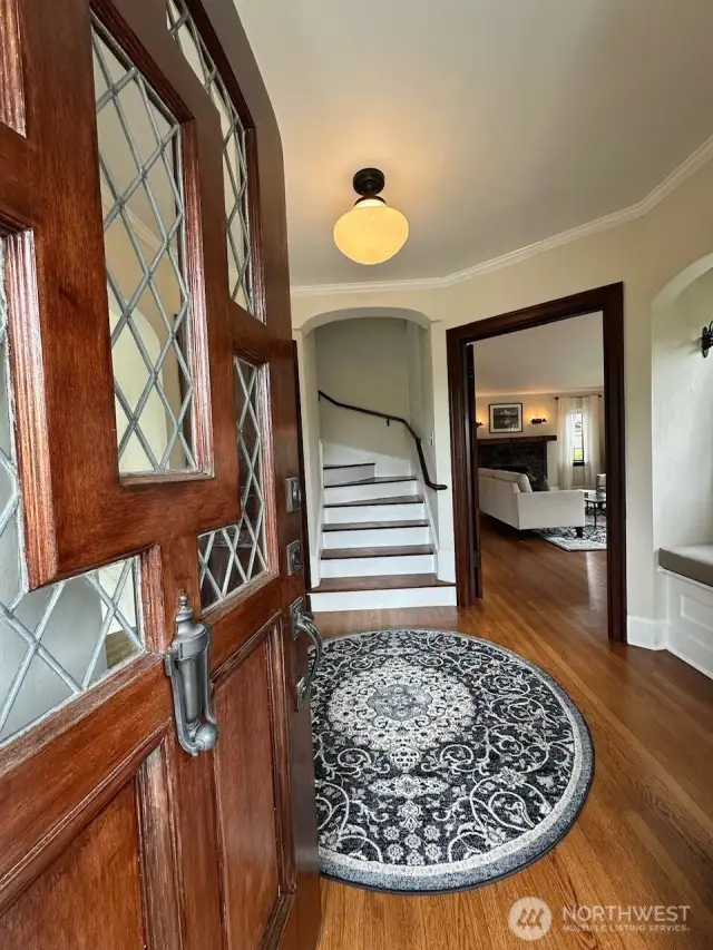 Arched leaded glass door leads to formal entry