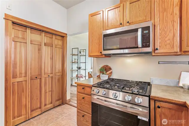Functional utility space with washer, dryer, and tankless water heater discreetly tucked behind closet doors.