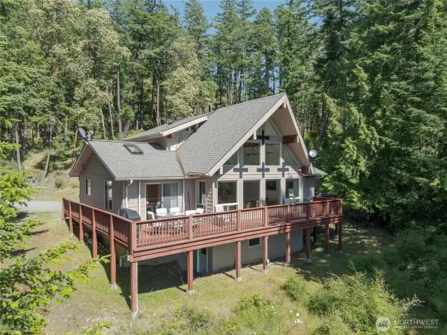 Step into your retreat with soaring windows, forested privacy, and stunning sunset views