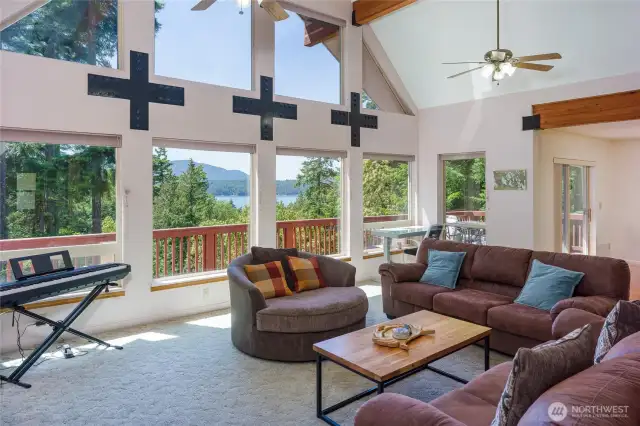 Sunlit living room welcomes you with floor-to-ceiling west-facing windows and captivating forest-to-sea views